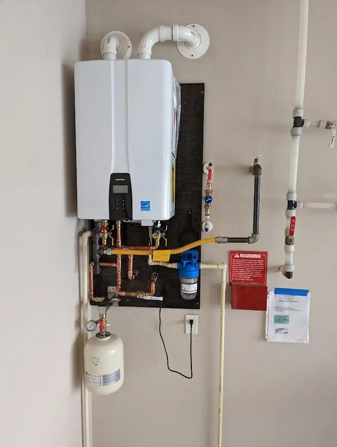 Professional plumber installing copper piping in a Randolph home